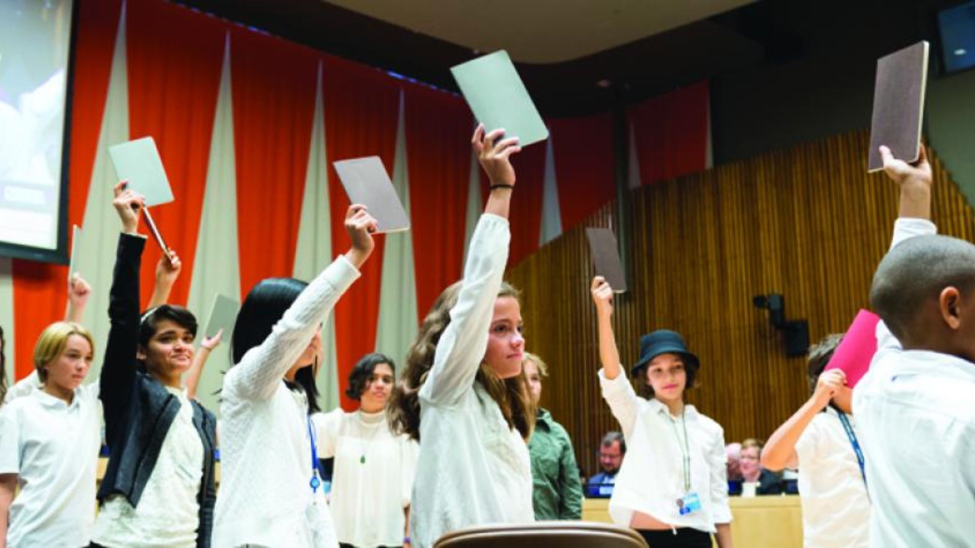 students standing, holding notepads 